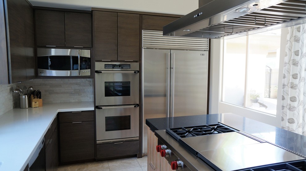 Inspiration for a mid-sized transitional u-shaped travertine floor and beige floor open concept kitchen remodel in Phoenix with a single-bowl sink, flat-panel cabinets, dark wood cabinets, quartz countertops, white backsplash, stone tile backsplash, stainless steel appliances and an island