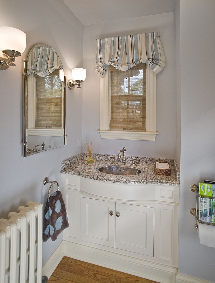 Mid-sized traditional powder room in Minneapolis with a drop-in sink, shaker cabinets, white cabinets, grey walls, light hardwood floors, granite benchtops and grey benchtops.