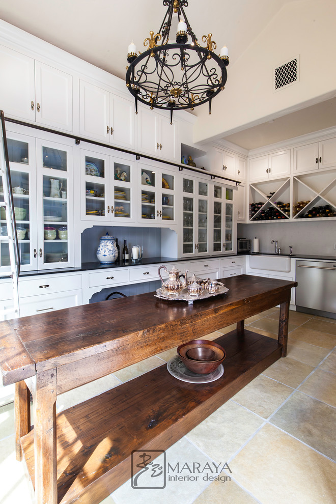 This is an example of an expansive traditional kitchen pantry in Santa Barbara with a farmhouse sink, recessed-panel cabinets, white cabinets, quartz benchtops, timber splashback, slate floors, with island, green floor and black benchtop.