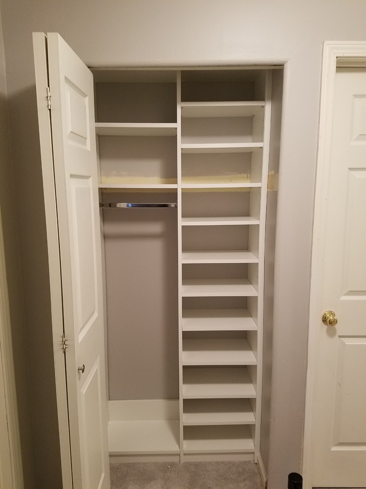 Design ideas for a small traditional gender-neutral built-in wardrobe in Louisville with open cabinets, white cabinets, carpet and brown floor.
