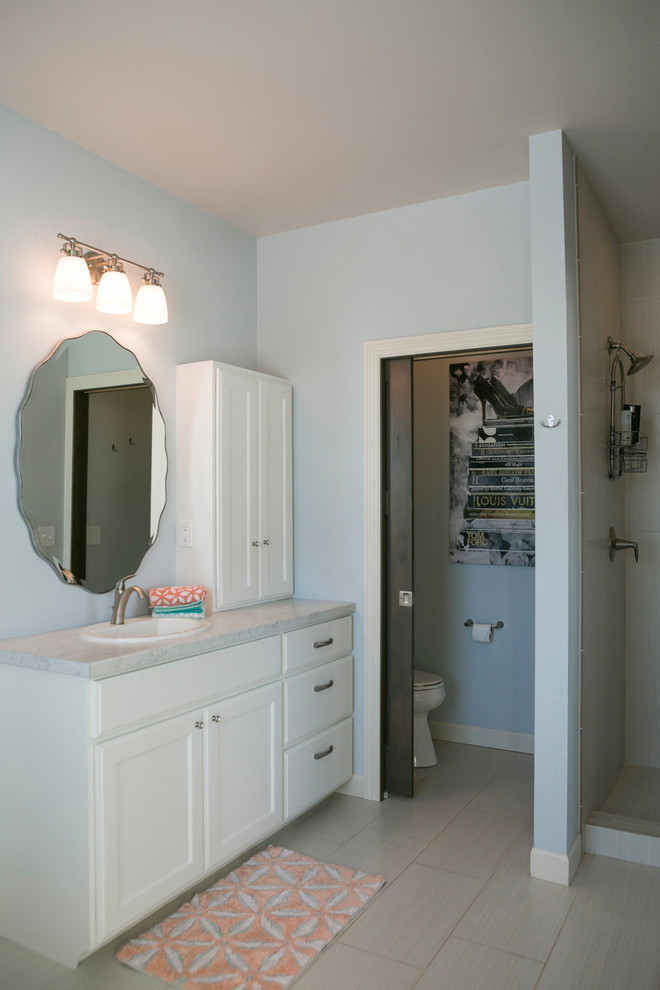 Inspiration for a large rustic kids' white tile porcelain tile and beige floor doorless shower remodel with recessed-panel cabinets, white cabinets, a one-piece toilet, white walls, a drop-in sink, solid surface countertops and beige countertops