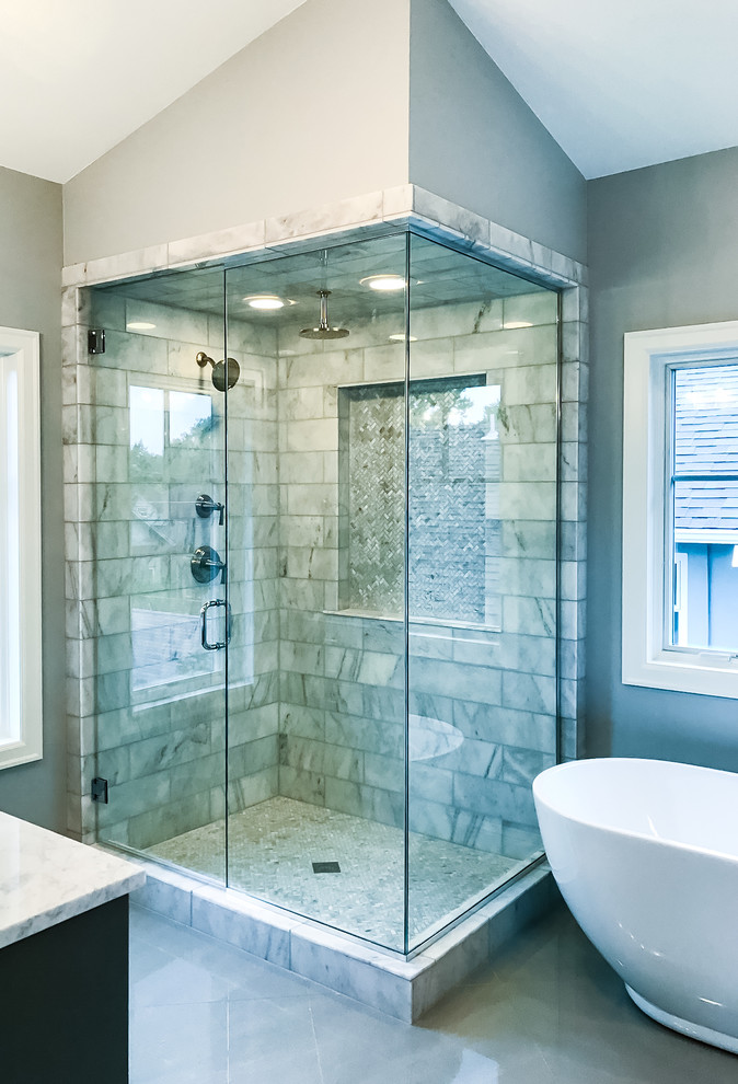 Freestanding bathtub - mid-sized transitional master multicolored tile and stone tile gray floor freestanding bathtub idea in Denver with dark wood cabinets, beige walls, marble countertops and a hinged shower door