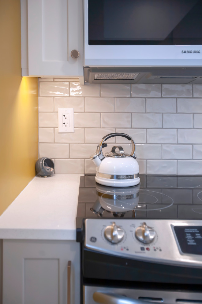 Inspiration for a mid-sized transitional single-wall eat-in kitchen remodel with an undermount sink, shaker cabinets, white cabinets, quartz countertops, porcelain backsplash, stainless steel appliances, no island and white countertops