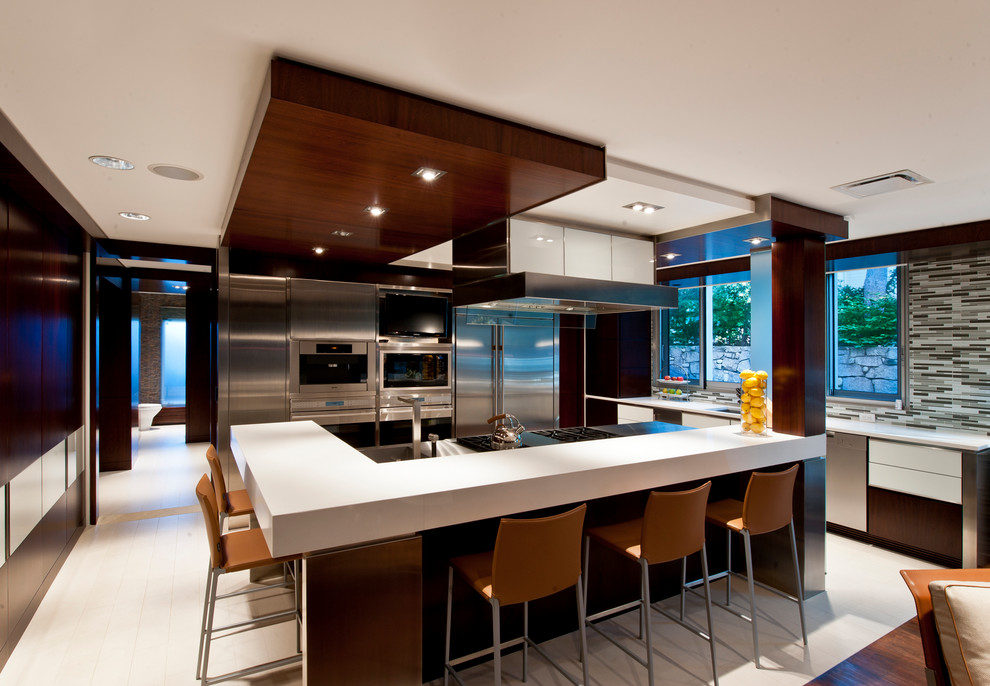 Contemporary open plan kitchen in New York with flat-panel cabinets, white cabinets, multi-coloured splashback, matchstick tile splashback, stainless steel appliances, with island, white floor and white benchtop.