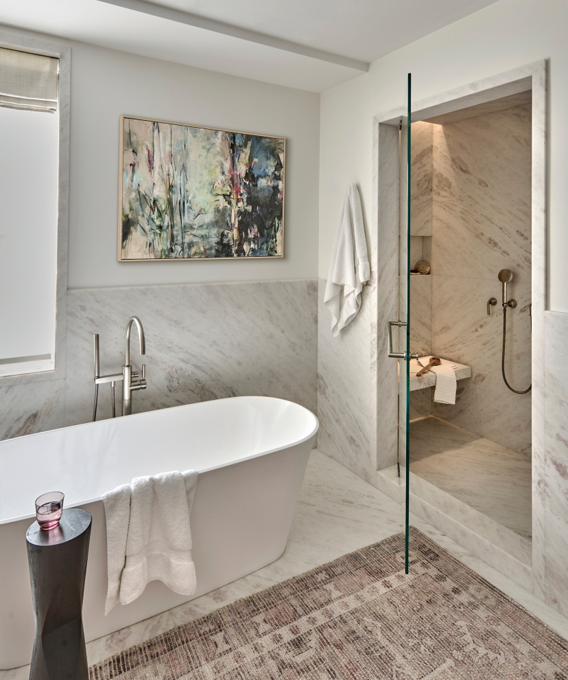 Large trendy master stone slab marble floor, white floor, single-sink and wainscoting freestanding bathtub photo in Chicago with white walls, marble countertops, a hinged shower door and white countertops