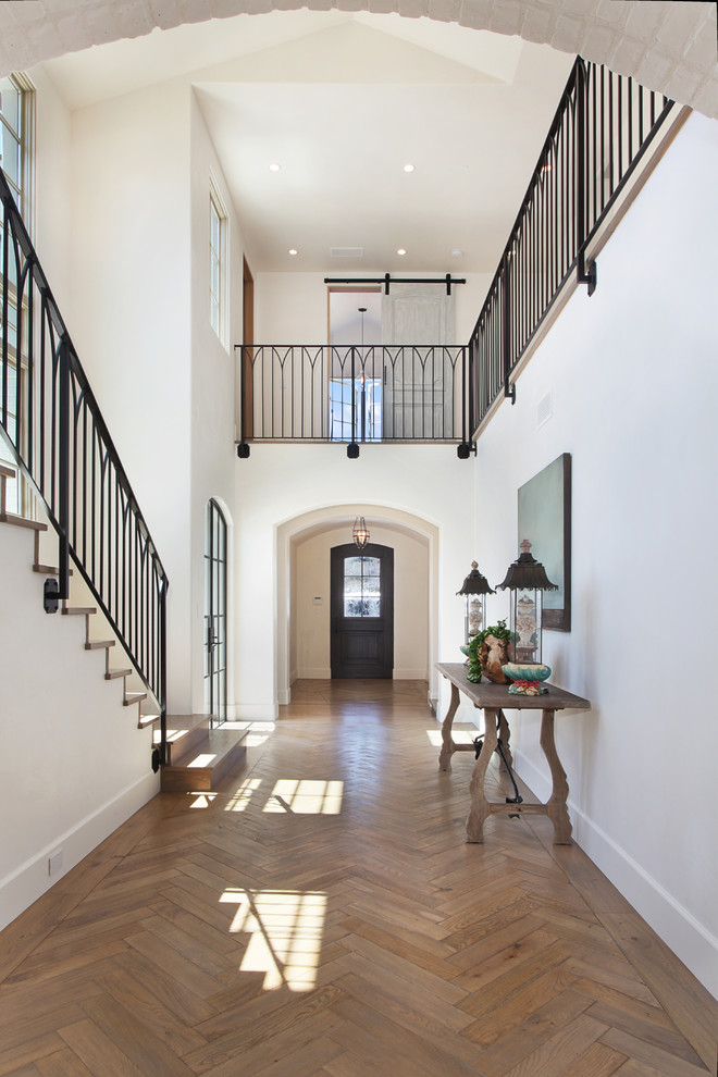 Photo of a large mediterranean entryway in Orange County with white walls.
