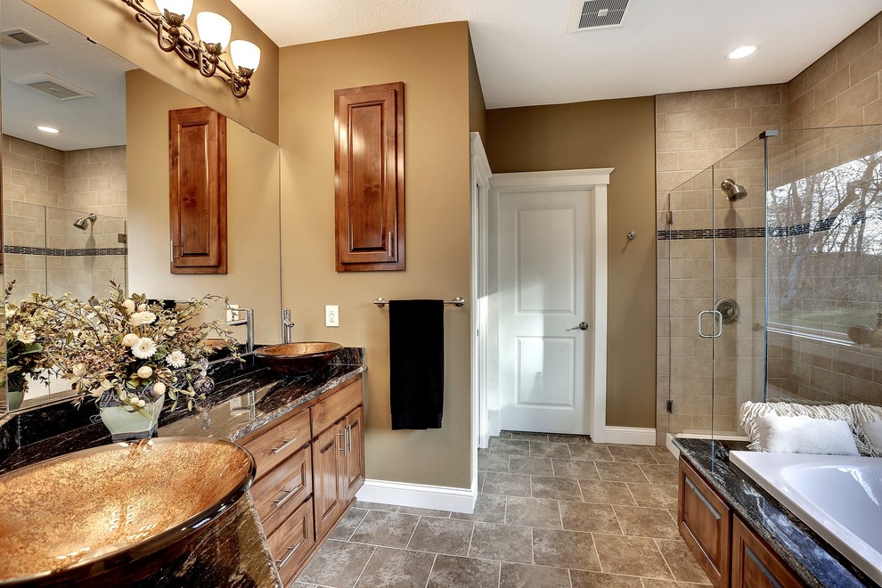 Large transitional master bathroom in Minneapolis with raised-panel cabinets, medium wood cabinets, a drop-in tub, a corner shower, brown walls, ceramic floors, a vessel sink and granite benchtops.