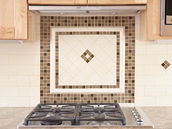 Example of a kitchen design in Boston with a single-bowl sink, recessed-panel cabinets, light wood cabinets, beige backsplash and stainless steel appliances