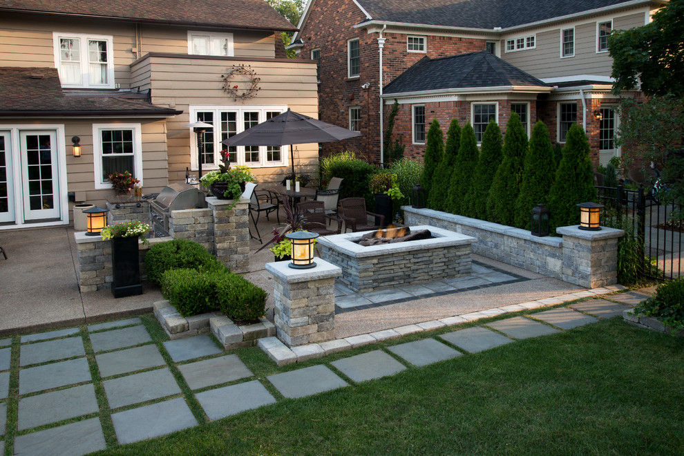 Photo of a mid-sized transitional backyard patio in Detroit with brick pavers, a fire feature and no cover.