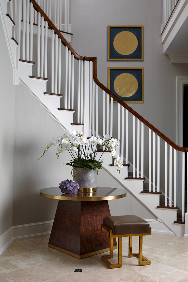 This is an example of a large transitional foyer in New York with grey walls.