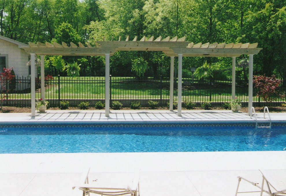 Example of a mid-sized transitional backyard concrete and rectangular pool design
