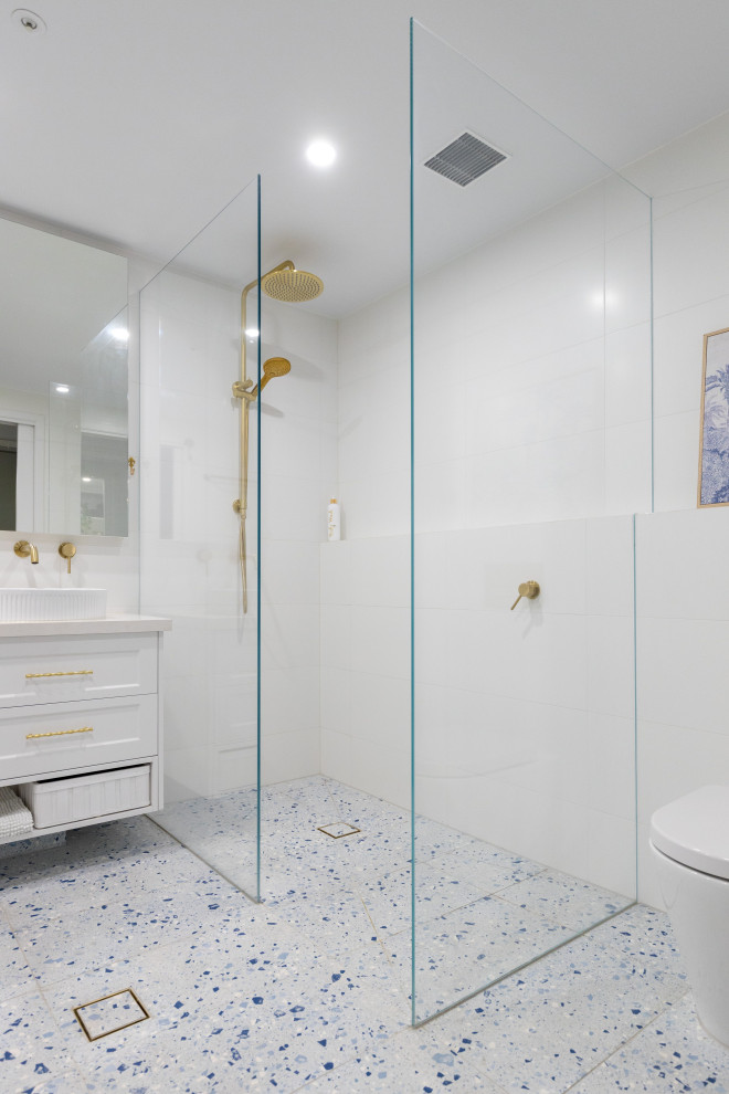 Example of a large minimalist master white tile and porcelain tile porcelain tile, blue floor and double-sink bathroom design in Melbourne with louvered cabinets, white cabinets, a wall-mount toilet, white walls, a vessel sink, quartz countertops, white countertops, a niche and a floating vanity