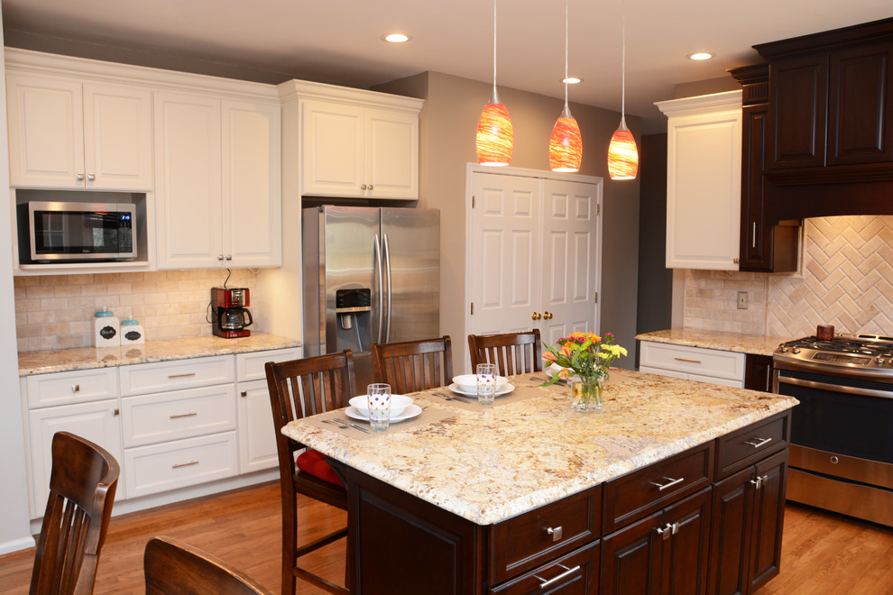 This is an example of a large traditional u-shaped eat-in kitchen in DC Metro with a double-bowl sink, raised-panel cabinets, white cabinets, granite benchtops, beige splashback, stainless steel appliances, light hardwood floors and with island.