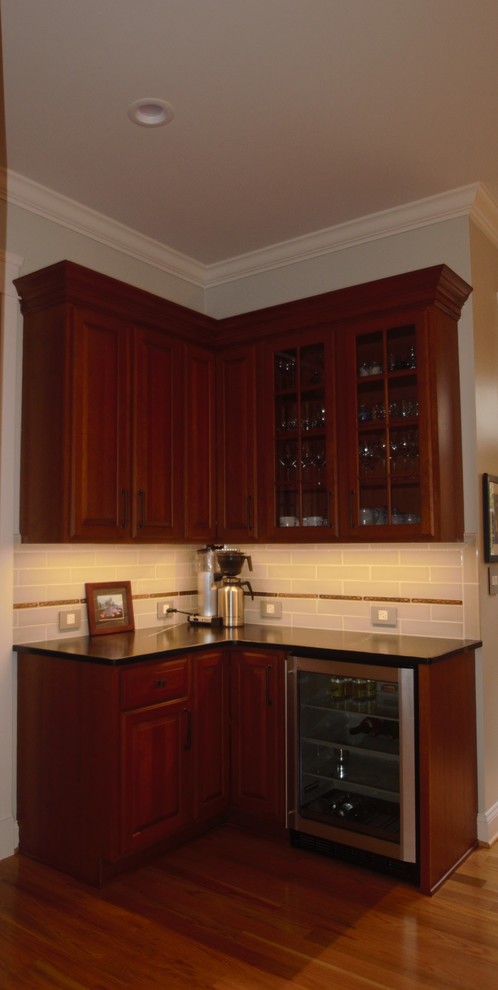 Inspiration for a large traditional u-shaped kitchen pantry in DC Metro with a farmhouse sink, raised-panel cabinets, medium wood cabinets, soapstone benchtops, green splashback, porcelain splashback, stainless steel appliances, medium hardwood floors, with island, brown floor and blue benchtop.