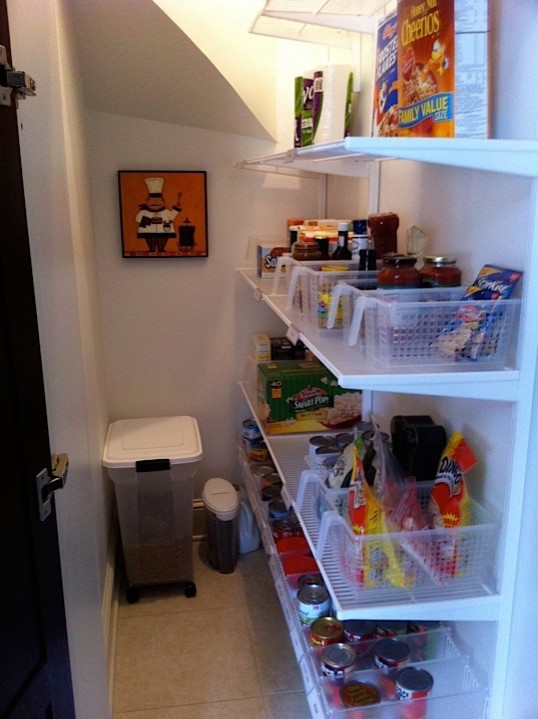 This is an example of a contemporary gender-neutral walk-in wardrobe in Chicago with white cabinets and porcelain floors.