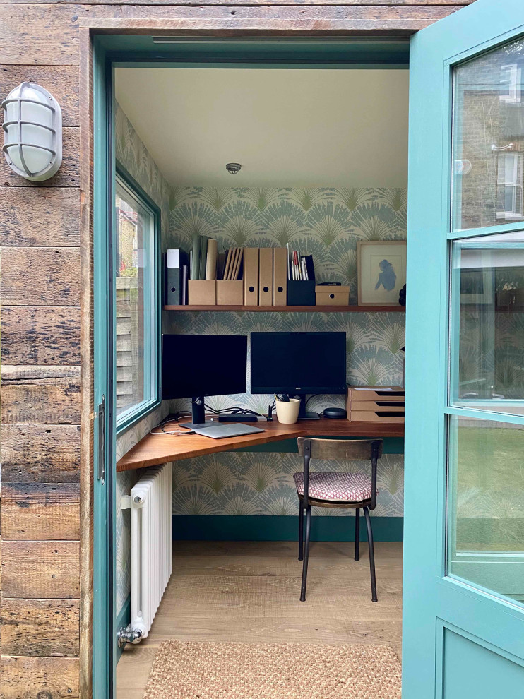Cette photo montre un petit bureau montagne avec un mur bleu, parquet clair, aucune cheminée, un bureau intégré, un sol beige et du papier peint.