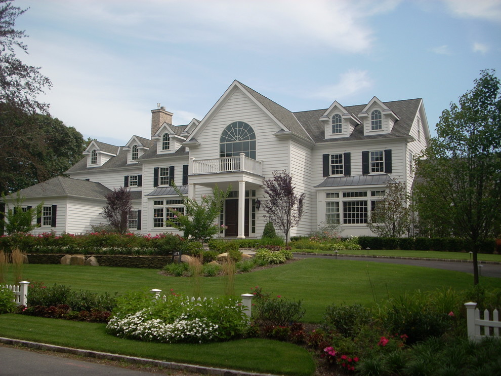 Photo of a large traditional three-storey exterior in New York with wood siding and a mixed roof.