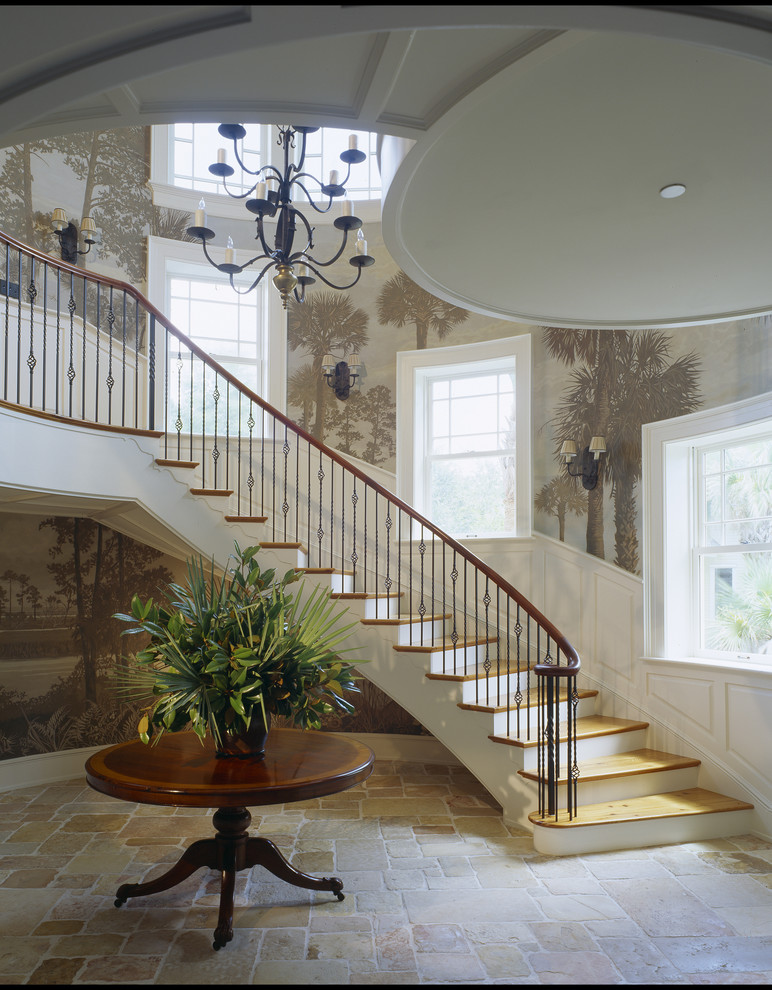 This is an example of a large beach style foyer in Charleston with travertine floors, a single front door and a dark wood front door.