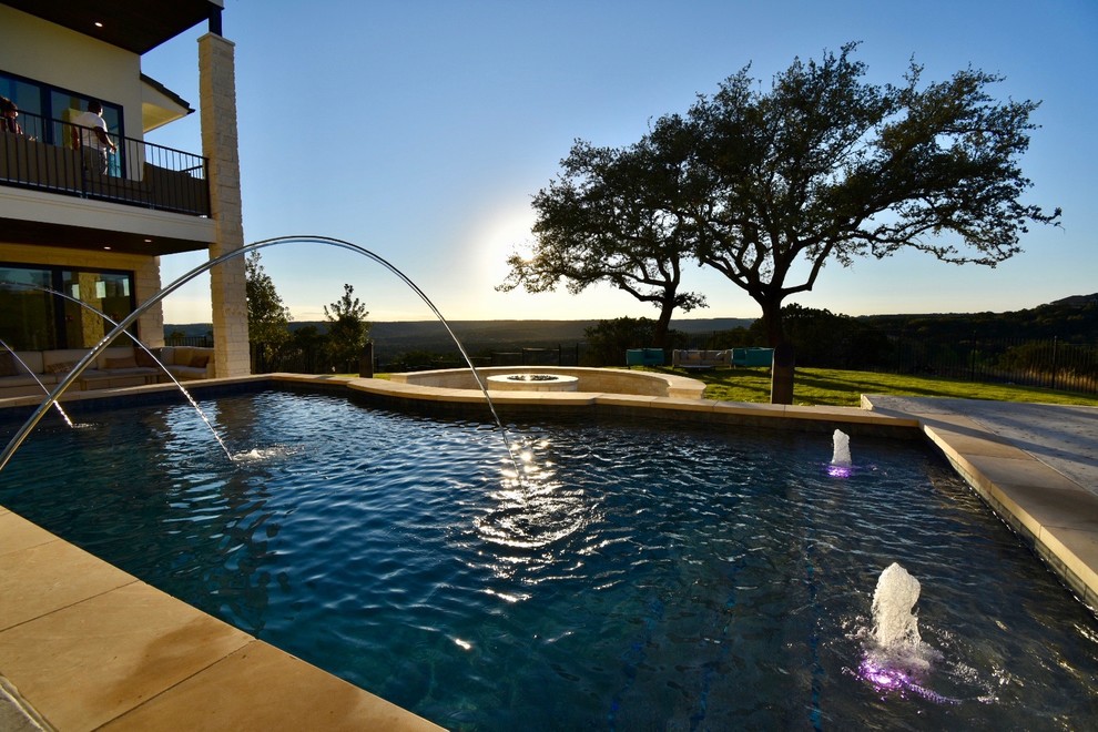 Photo of a mid-sized contemporary backyard rectangular pool in Austin with a water feature and concrete slab.