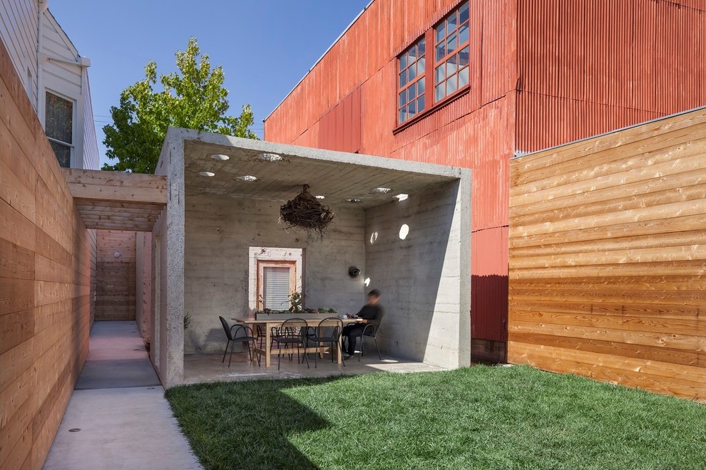 This is an example of a mid-sized industrial backyard patio in San Francisco with concrete slab and a gazebo/cabana.