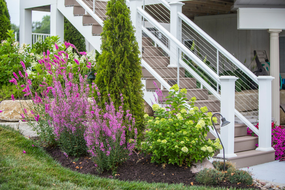 Geräumiger Klassischer Gartenkamin hinter dem Haus mit Natursteinplatten, direkter Sonneneinstrahlung und Metallzaun in Kansas City