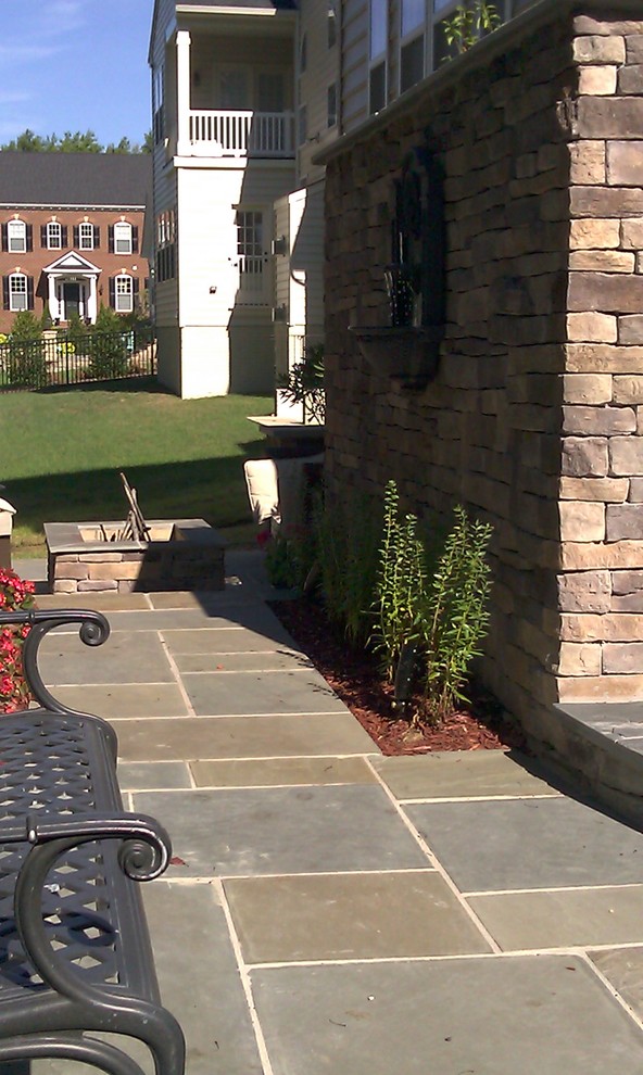 Large transitional backyard stone patio photo in DC Metro with a fire pit and no cover