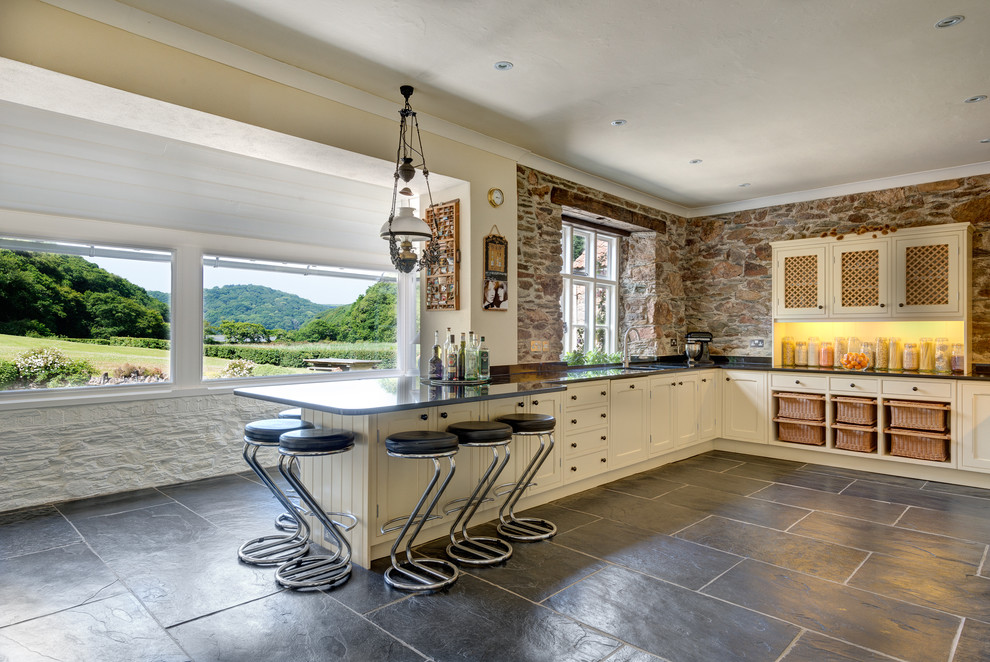 Inspiration for an expansive country eat-in kitchen in Devon with shaker cabinets, white cabinets and granite benchtops.