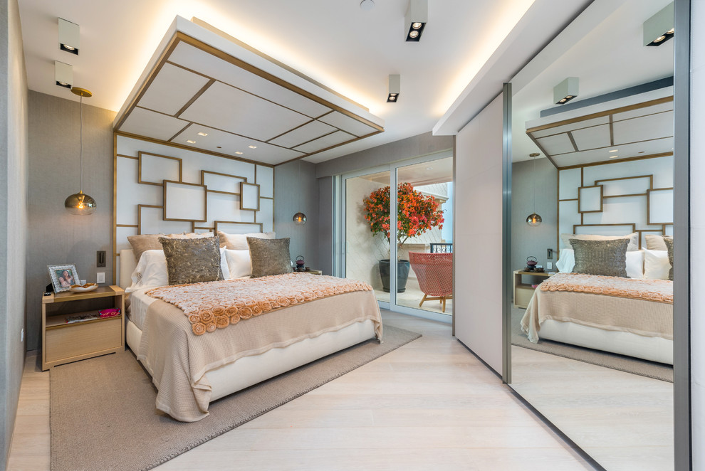 Large contemporary master bedroom in Miami with grey walls, light hardwood floors and beige floor.