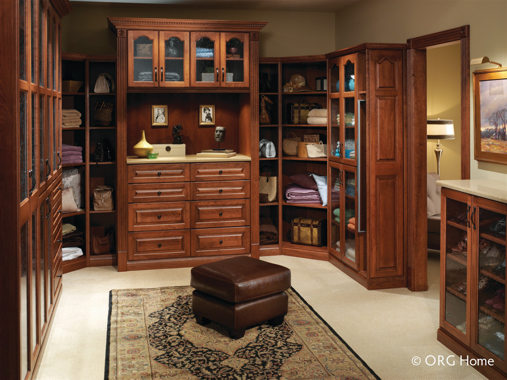 Large contemporary gender-neutral dressing room in Other with raised-panel cabinets, medium wood cabinets, carpet and beige floor.