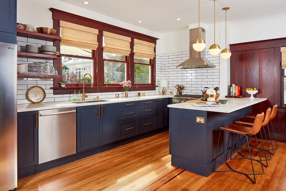 Traditional kitchen in San Francisco with an undermount sink, shaker cabinets, blue cabinets, white splashback, subway tile splashback, stainless steel appliances, medium hardwood floors and a peninsula.