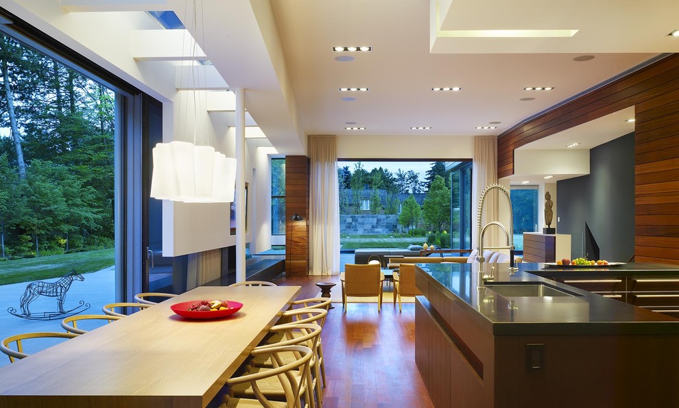 Large modern open plan dining in Toronto with white walls, medium hardwood floors, a corner fireplace and a metal fireplace surround.