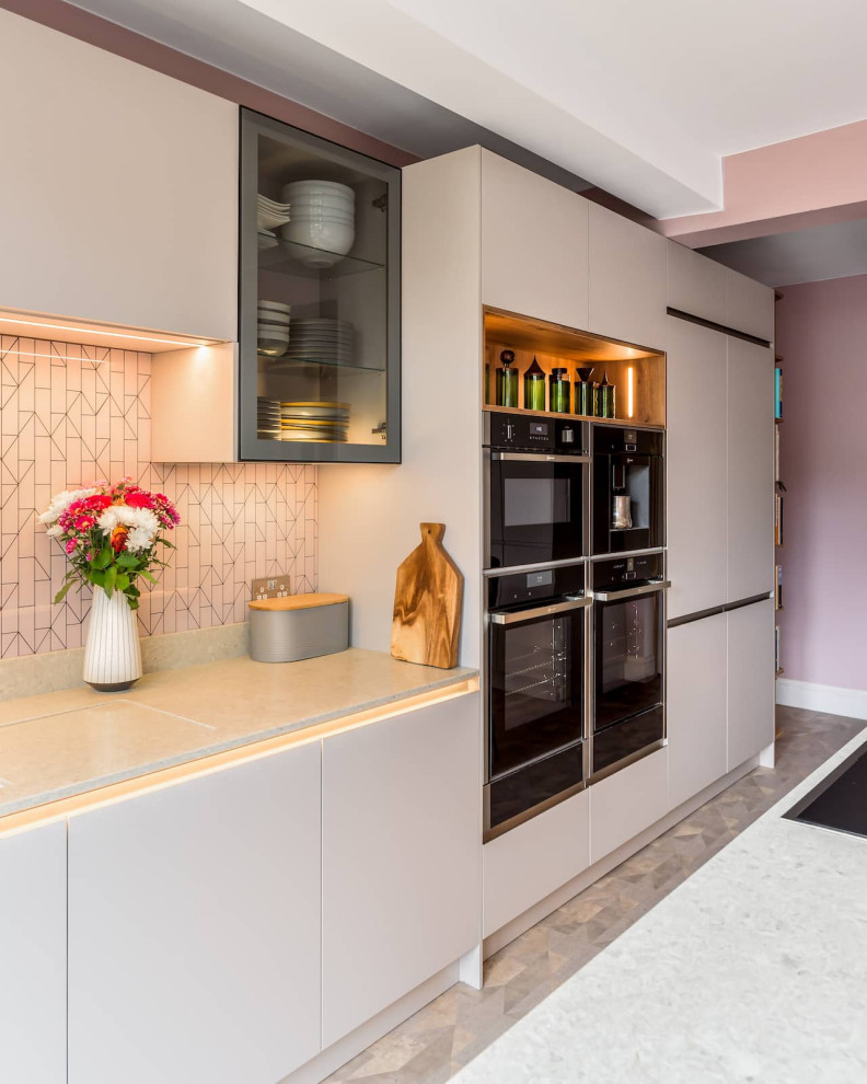 Immagine di una grande cucina contemporanea con ante lisce, ante rosa, top in quarzite e elettrodomestici neri