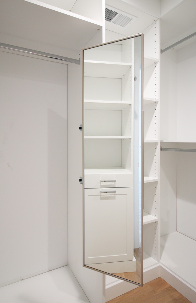 This is an example of a large modern gender-neutral walk-in wardrobe in Chicago with shaker cabinets and white cabinets.