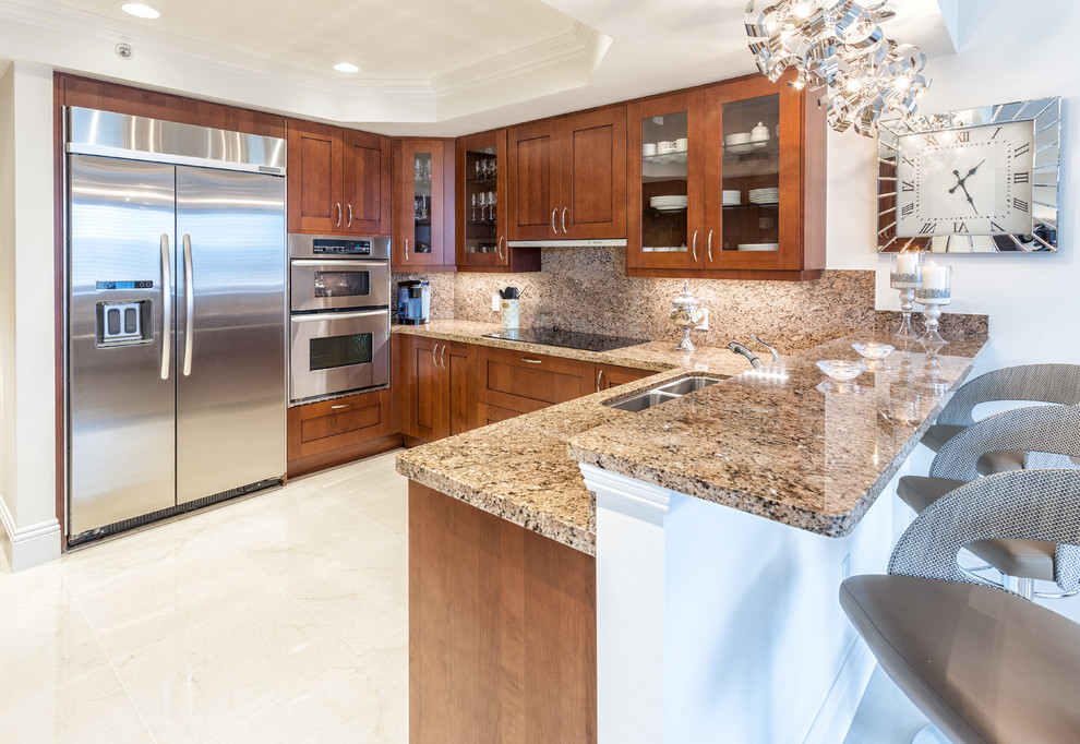 Inspiration for a large transitional galley marble floor kitchen remodel in Miami with an undermount sink, shaker cabinets, medium tone wood cabinets, granite countertops, multicolored backsplash and stainless steel appliances
