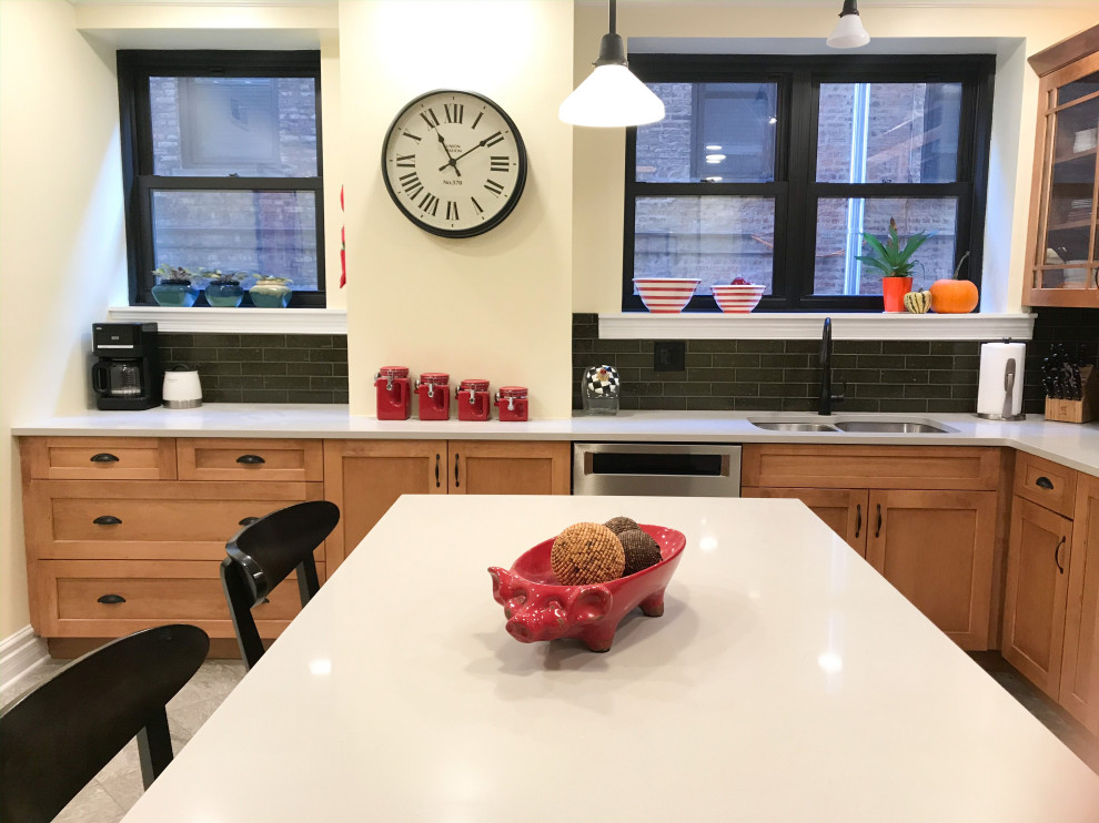 Mid-sized transitional l-shaped eat-in kitchen photo in Chicago with an undermount sink, shaker cabinets, brown cabinets, green backsplash, stainless steel appliances, an island and gray countertops