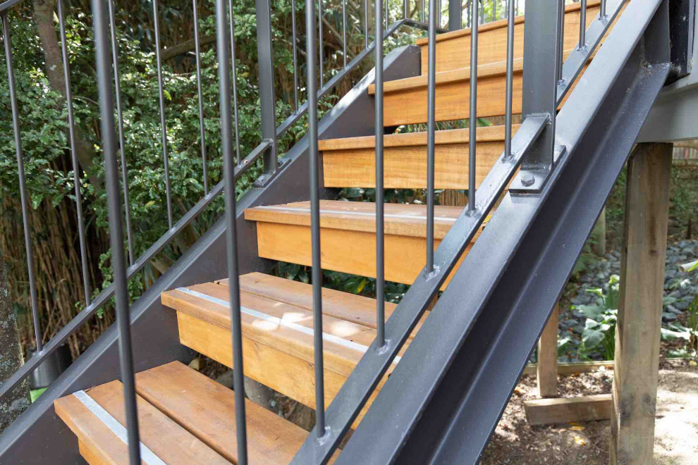 Mid-sized industrial wood l-shaped staircase in Auckland with wood risers and metal railing.