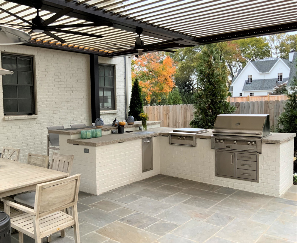 На фото: большой двор на заднем дворе в современном стиле с летней кухней и покрытием из каменной брусчатки