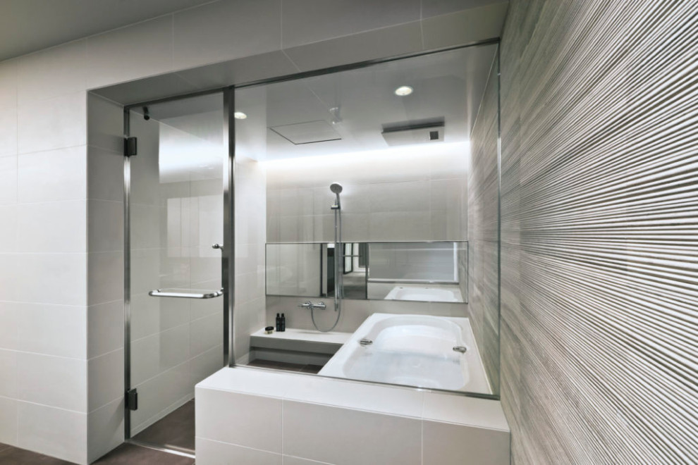 Ejemplo de cuarto de baño minimalista con baldosas y/o azulejos blancos, paredes blancas, bañera encastrada, suelo marrón y bandeja