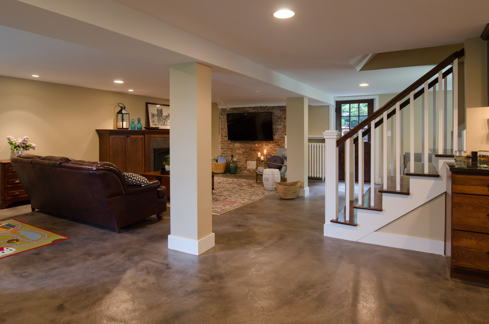 Design ideas for a mid-sized arts and crafts walk-out basement in Seattle with beige walls, concrete floors, a tile fireplace surround, grey floor and a standard fireplace.