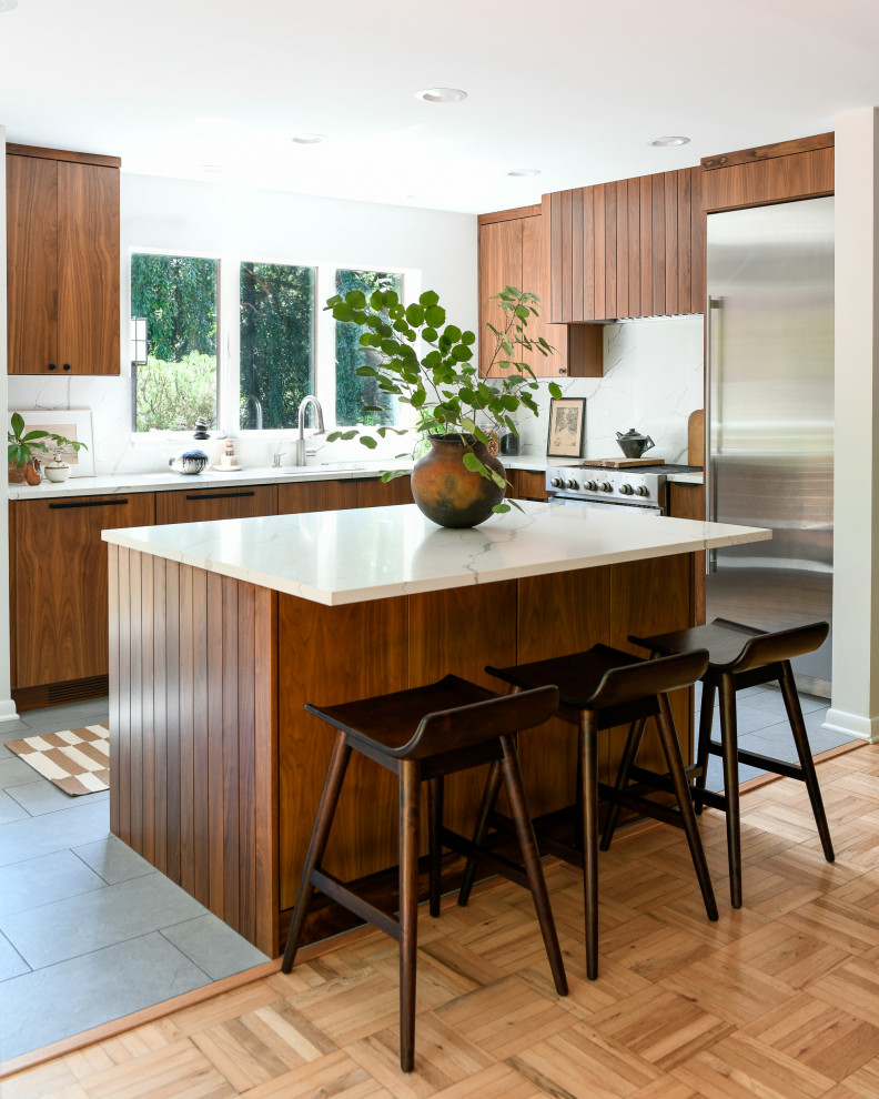Photo of a large midcentury galley kitchen/diner in Other with a built-in sink, flat-panel cabinets, dark wood cabinets, marble worktops, white splashback, marble splashback, stainless steel appliances, ceramic flooring, an island, grey floors and white worktops.