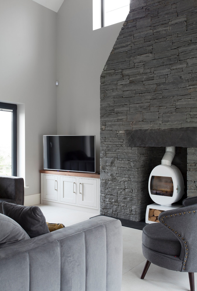 Large contemporary open concept living room in Other with grey floor, grey walls and a freestanding tv.