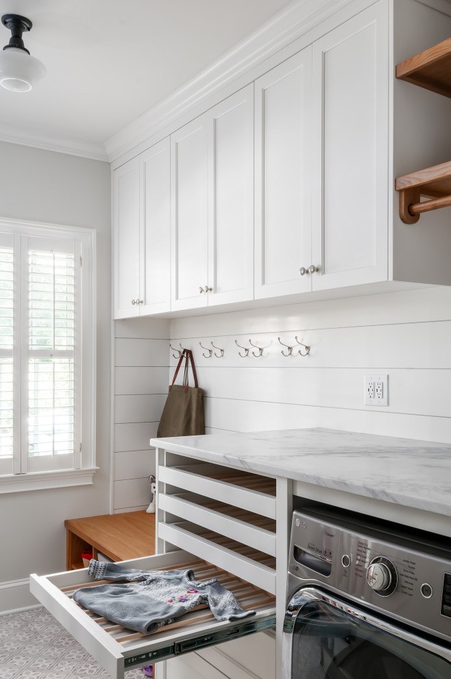This is an example of a traditional utility room in Atlanta with an undermount sink, shaker cabinets, white cabinets, marble benchtops, grey walls, ceramic floors, a side-by-side washer and dryer, grey floor and white benchtop.