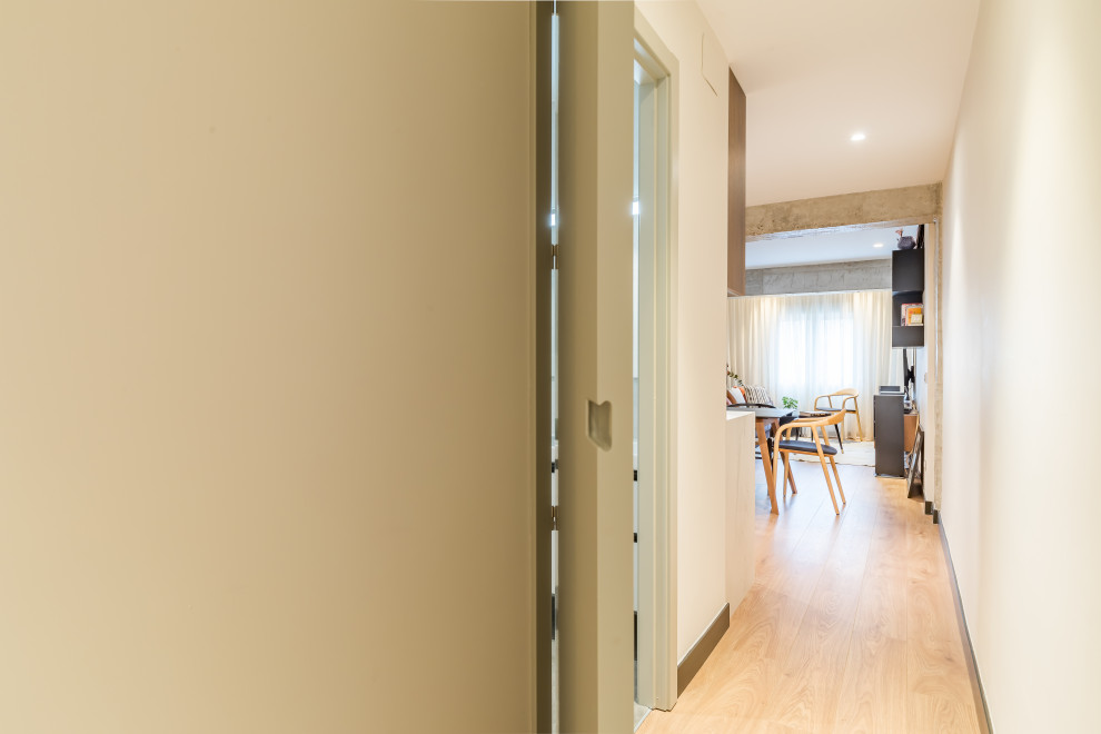 Idée de décoration pour un couloir urbain de taille moyenne avec un mur gris, un sol en carrelage de porcelaine et un sol beige.