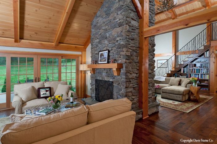 This is an example of an expansive arts and crafts open concept family room in Burlington with dark hardwood floors, a two-sided fireplace and a stone fireplace surround.