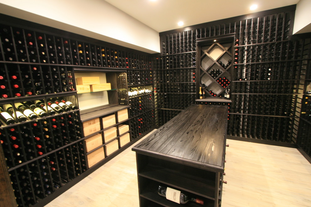 Photo of a mid-sized modern wine cellar in New York with storage racks, light hardwood floors and beige floor.