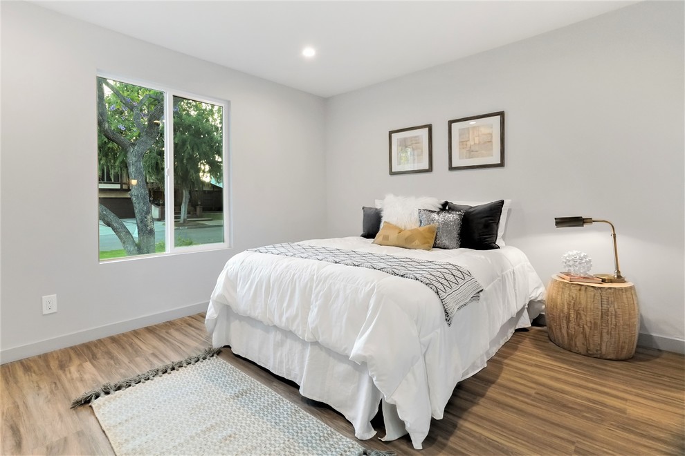 This is an example of a mid-sized contemporary guest bedroom in Los Angeles with grey walls, no fireplace and vinyl floors.
