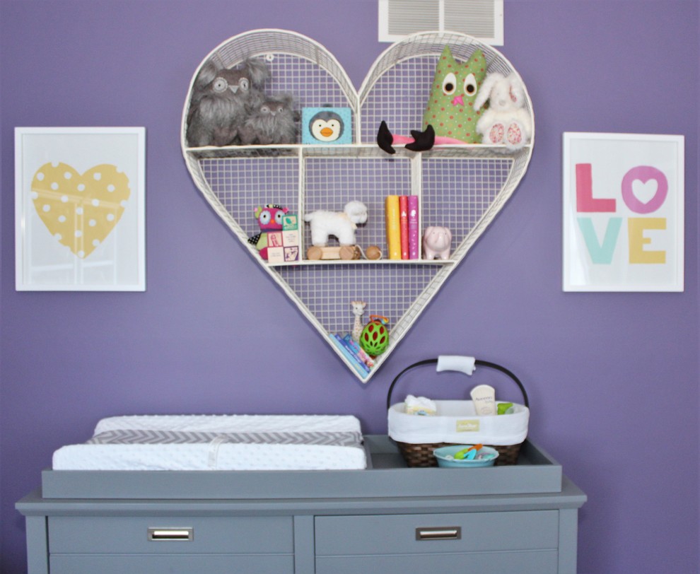 Photo of a small transitional nursery for girls in Philadelphia with purple walls and light hardwood floors.