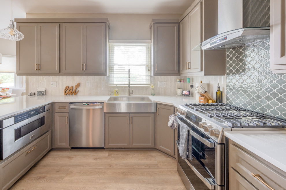 Example of a transitional kitchen design in Philadelphia with shaker cabinets, quartz countertops, stainless steel appliances and white countertops