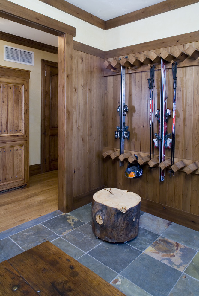 Inspiration for a mid-sized country mudroom in New York with beige walls and slate floors.