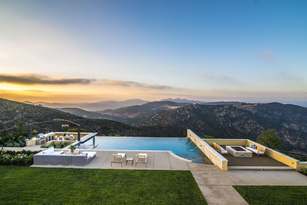 Design ideas for a contemporary custom-shaped infinity pool in San Diego with concrete slab.